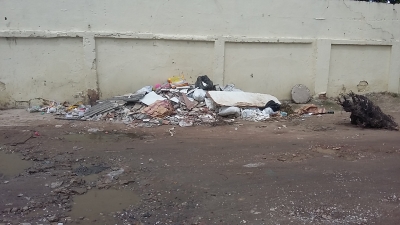 Lixo e entulhos deixados em muro de escola